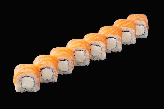 Sushi roll met zalm, philadelphia kaas geïsoleerd op zwart