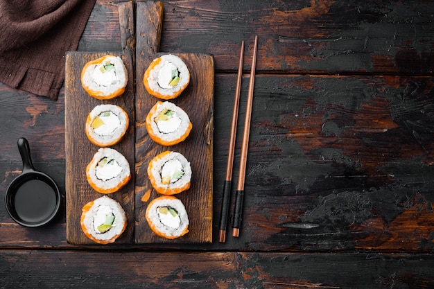 Sushi roll Row of salmon and  tuna with chopsticks set, on old dark  wooden table