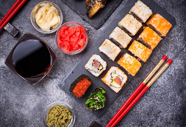 Sushi and roll set on black table