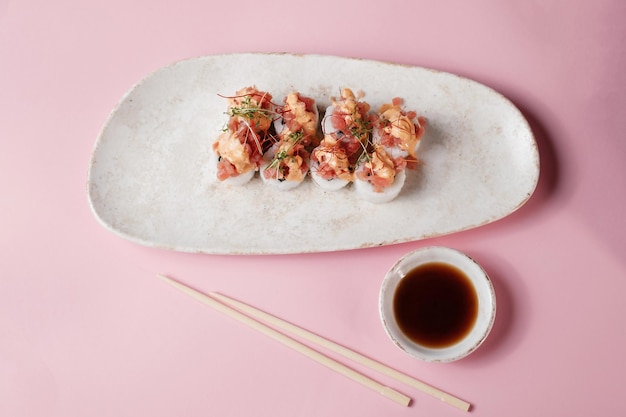 Sushi roll set met stokjes op roze achtergrond bovenaanzicht