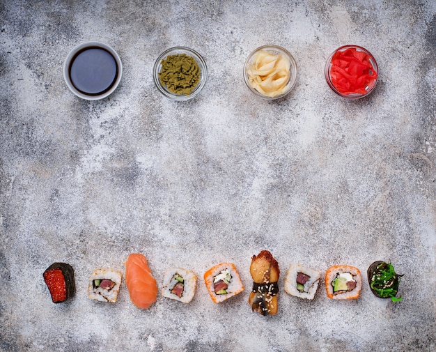 Foto rotolo di sushi con salsa di wasabi, zenzero e soia.