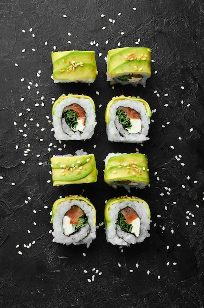 Rotolo di sushi con avocado, salmone e cipolla spazio libero per il testo cucina tradizionale giapponese vista dall'alto stile rustico