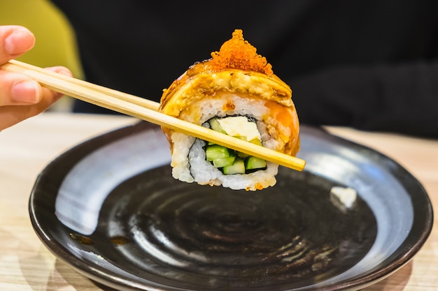 Foto rotolo di sushi con bacchette