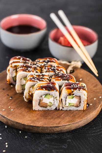 Sushi roll with eel, salmon, cucumber and cream cheese on a dark surface