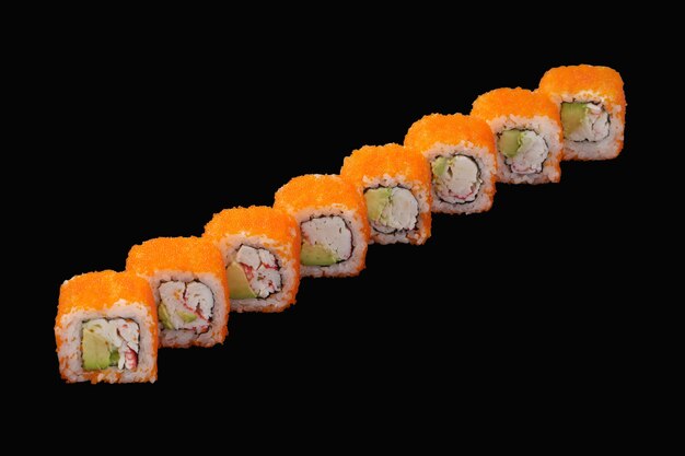 Sushi roll con granchio di neve, avocado, caviale di masago, maionese giapponese isolato su fondo nero