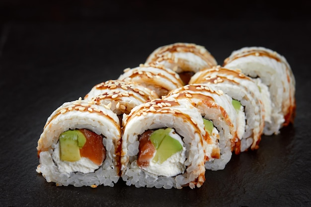 Sushi roll with tuna avocado and cream cheese on a black background