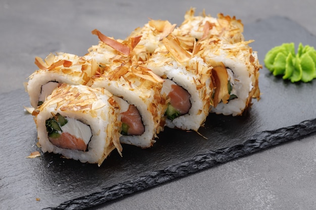 Sushi roll with tuna shavings on plate close up photo