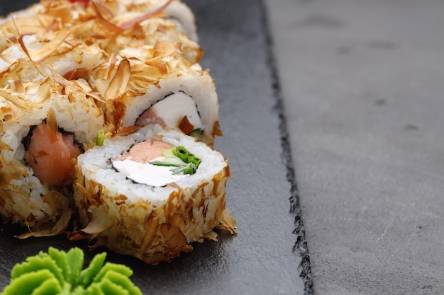 Sushi roll with tuna shavings on plate close up