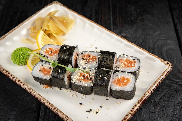 sushi roll with wasabi and sesame seeds on the plate. delicious food, close-up