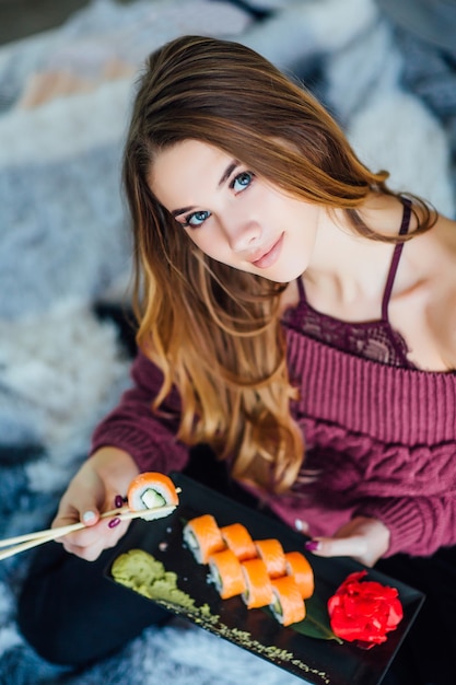 Foto rotolo di sushi sulle mani della donna