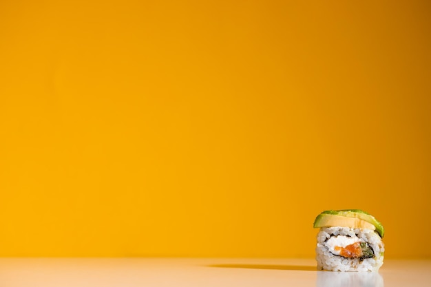 Photo sushi roll over yellow background sushi roll with eel tofu vegetables and avocado closeup