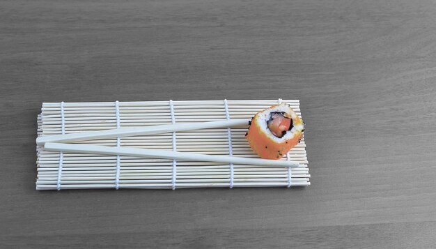 Sushi rolls and chopsticks on wooden background