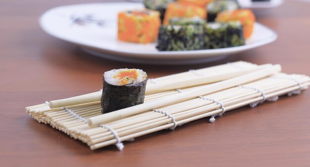 Sushi rolls and chopsticks on a wooden table