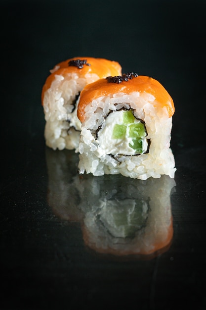 Sushi rotoli pesce salmone, verdure, riso wasabi allo zenzero e nori sul tavolo