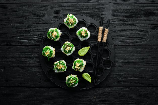 Sushi rolls Kyoto met zalm, komkommer en Chuka salade Sushi menubar Japans eten