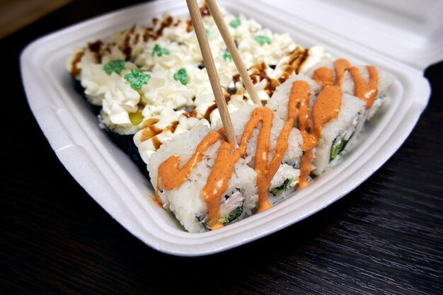 Sushi rolls in a plastic container Home delivery