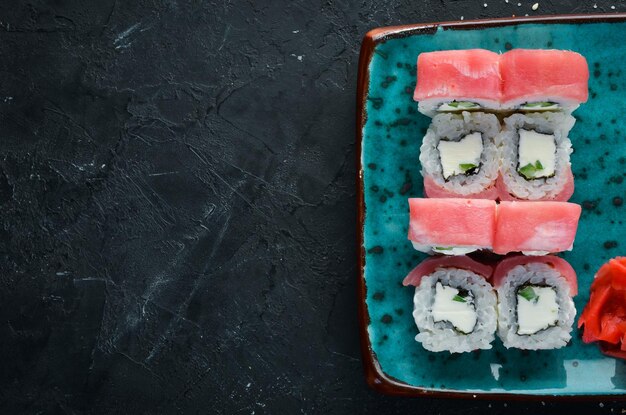 Sushi and rolls on the plate Top view Free space for your text On a black background