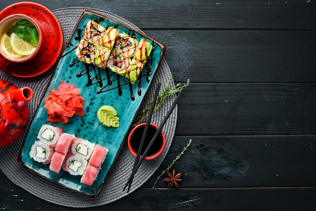 Sushi and rolls on the plate Top view Free space for your text On a black background