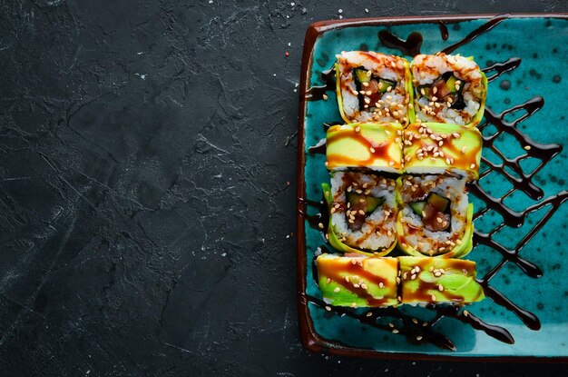 Sushi and rolls on the plate Top view Free space for your text On a black background