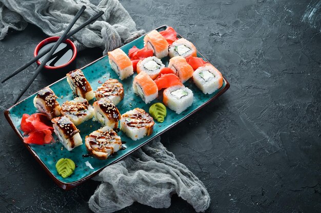 Sushi and rolls on the plate Top view Free space for your text On a black background