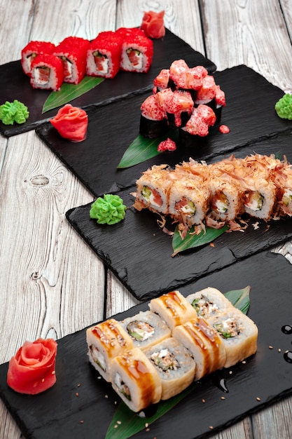 Sushi rolls served on boards on dark wooden background