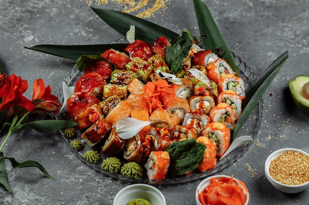 Sushi rolls set on a crystal tray. Rolls: Philadelphia, Green Dragon, Hawaii, Red Dragon, Ebi Shake.