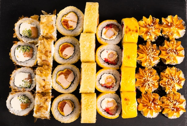 Sushi rolls set on dark background Japanese and asian food concept