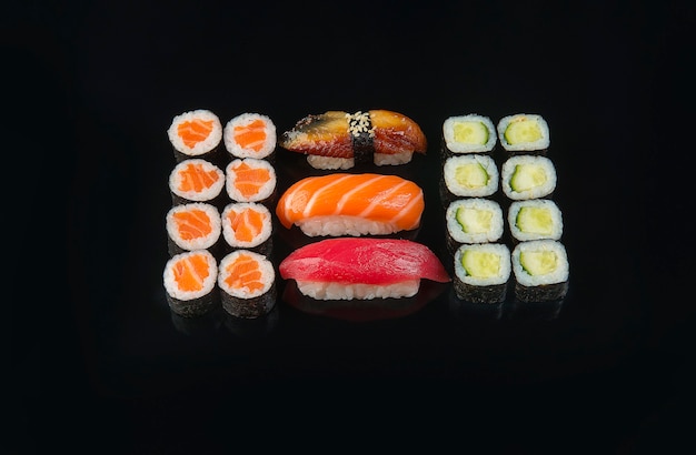 黒の背景で提供される巻き寿司セット