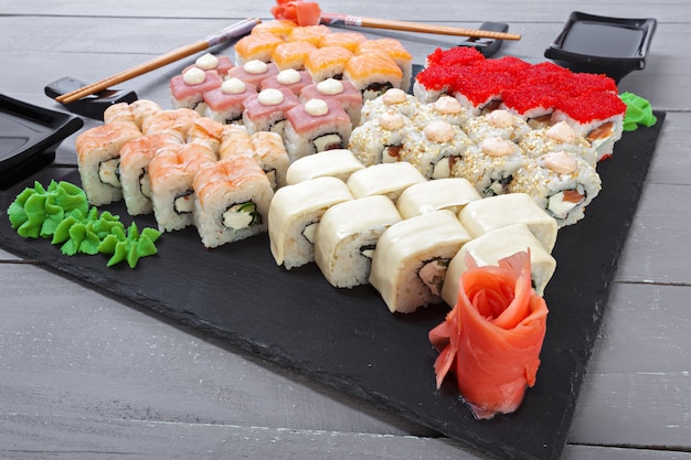 Sushi rolls set served on slate on dark background