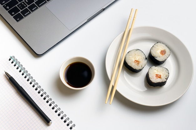 Foto rotoli di sushi snacking al lavoro. pausa per mangiare sushi.