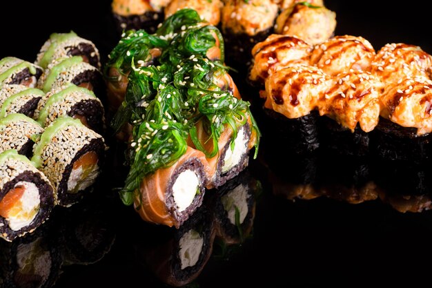 Foto sushi rotoli sushi su uno sfondo nero cozze