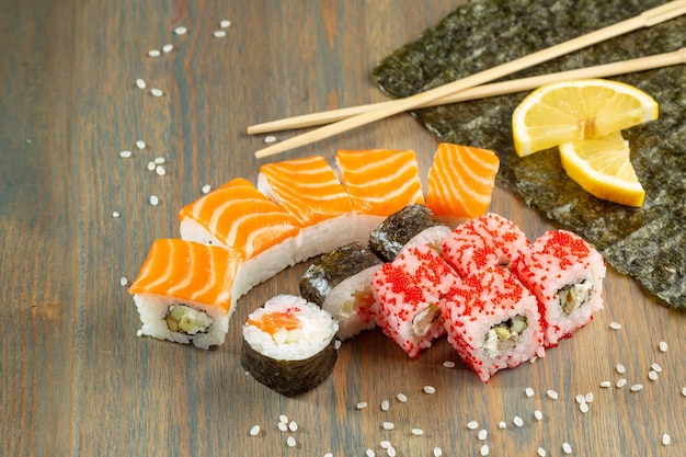 Sushi and rolls with salmon on a wooden board