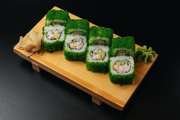 Sushi Rolls With Tobiko Green Caviar on wooden board