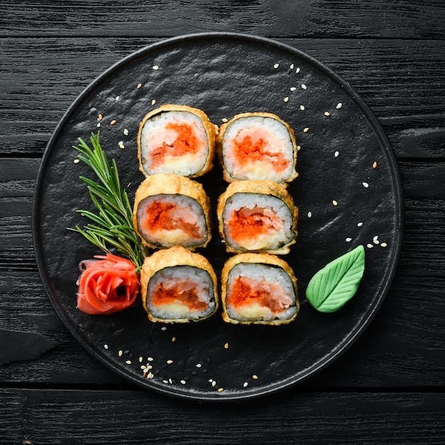 Sushi rolls with tuna and caviar Sushi set on a black stone plate Top view