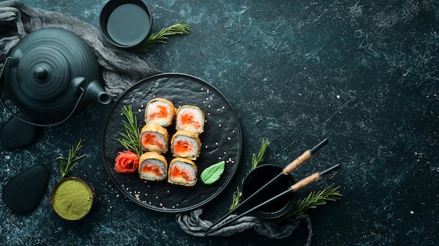 Sushi rolls with tuna and caviar Sushi set on a black stone plate Top view