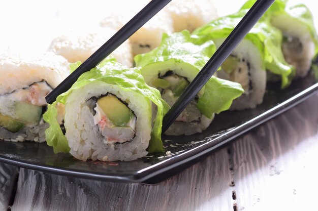 Sushi rolls on wooden background