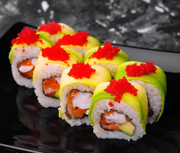 sushi rolls wrapped with avocado and shrimp inside