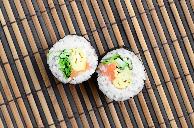 Sushi rolt leugens op een bamboe stro serwing mat