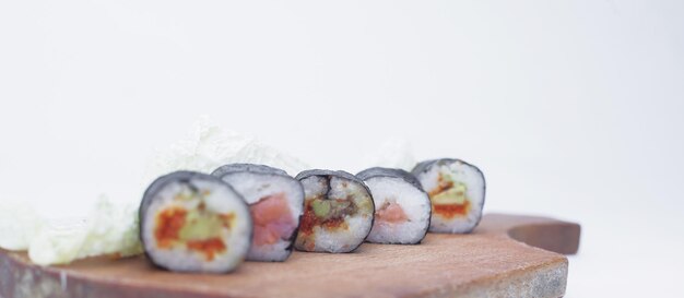 Sushi rolt op een snijplank geïsoleerd op wit