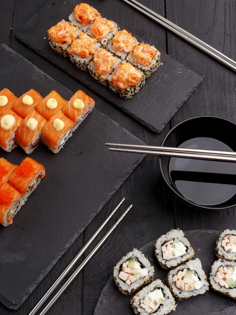 Sushi rolt op gekleurde platen op een zwarte achtergrond