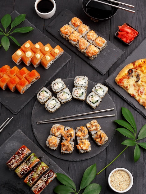 Sushi rolt op gekleurde platen op een zwarte achtergrond