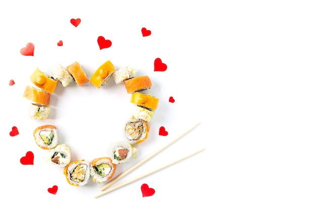 Sushi rolt voor Valentijnsdag in de vorm van een hart op een witte achtergrond.