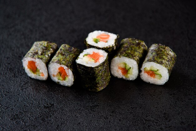 Sushi rolt zeevruchten. Sushi bezorging vanuit het restaurant. Verse heerlijke Japanse sushi met avocado, komkommer, garnalen en kaviaar