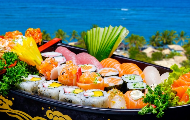 Sushi sashimi set in a wooden boat on a brown wooden table With tune prawn shrimp ginger