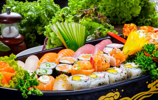 Sushi sashimi set in a wooden boat on a brown