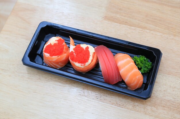 Sushi seafood set on black tray on wood table