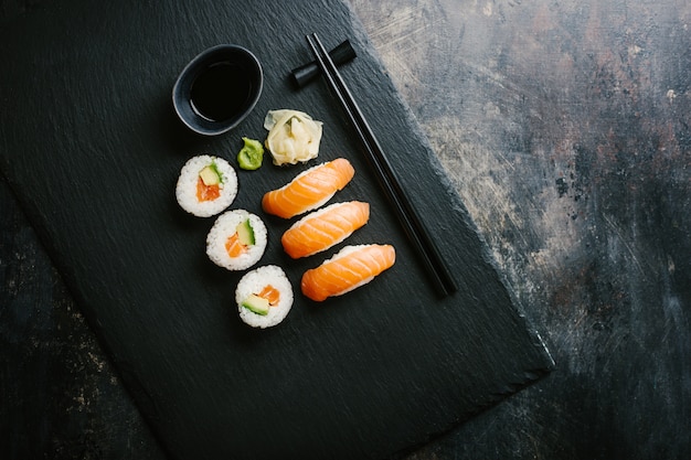 Sushi served on plate on dark table