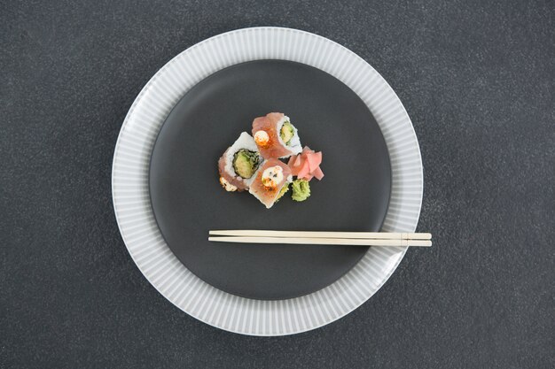 Foto sushi serviti sul piatto con le bacchette