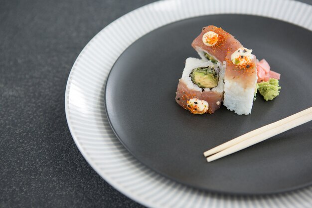 Sushi served on plate with chopsticks