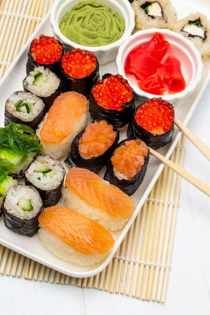 Sushi set bowls with wasabi and pink ginger on a plate